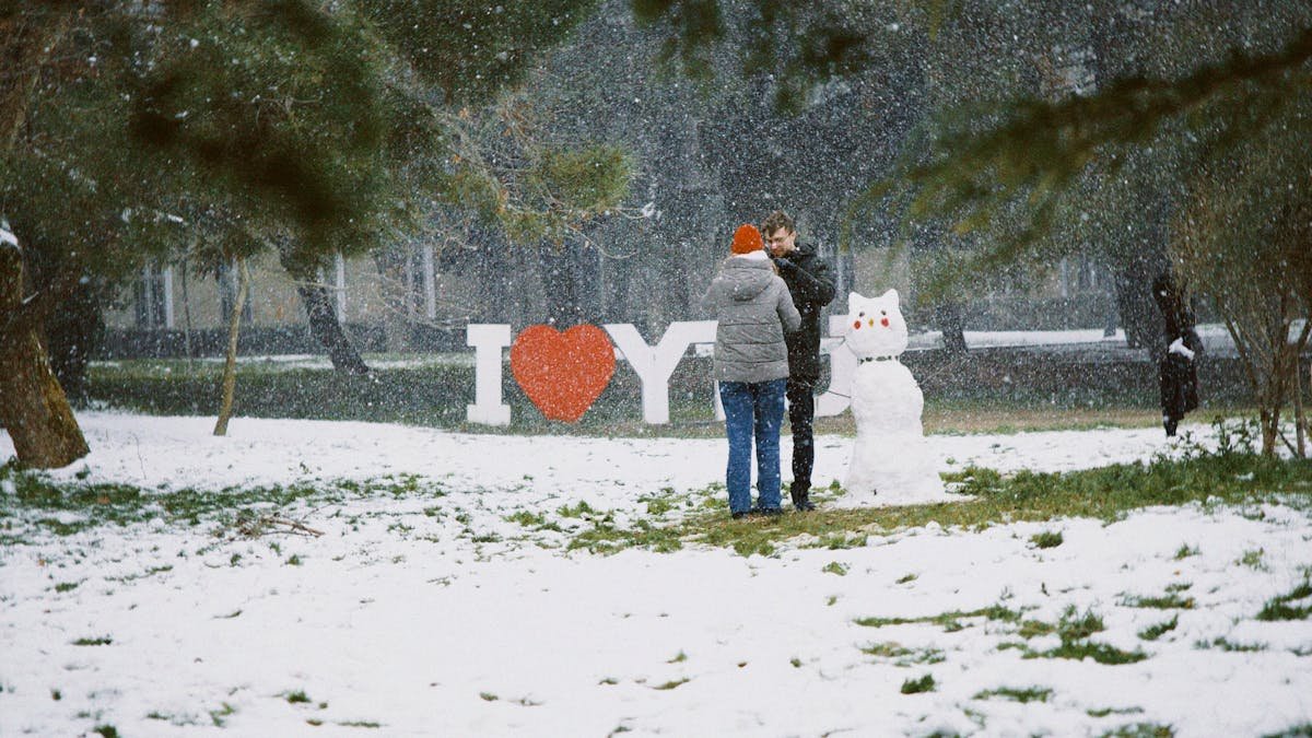 Couple Building Snowman in Winter Wonderland